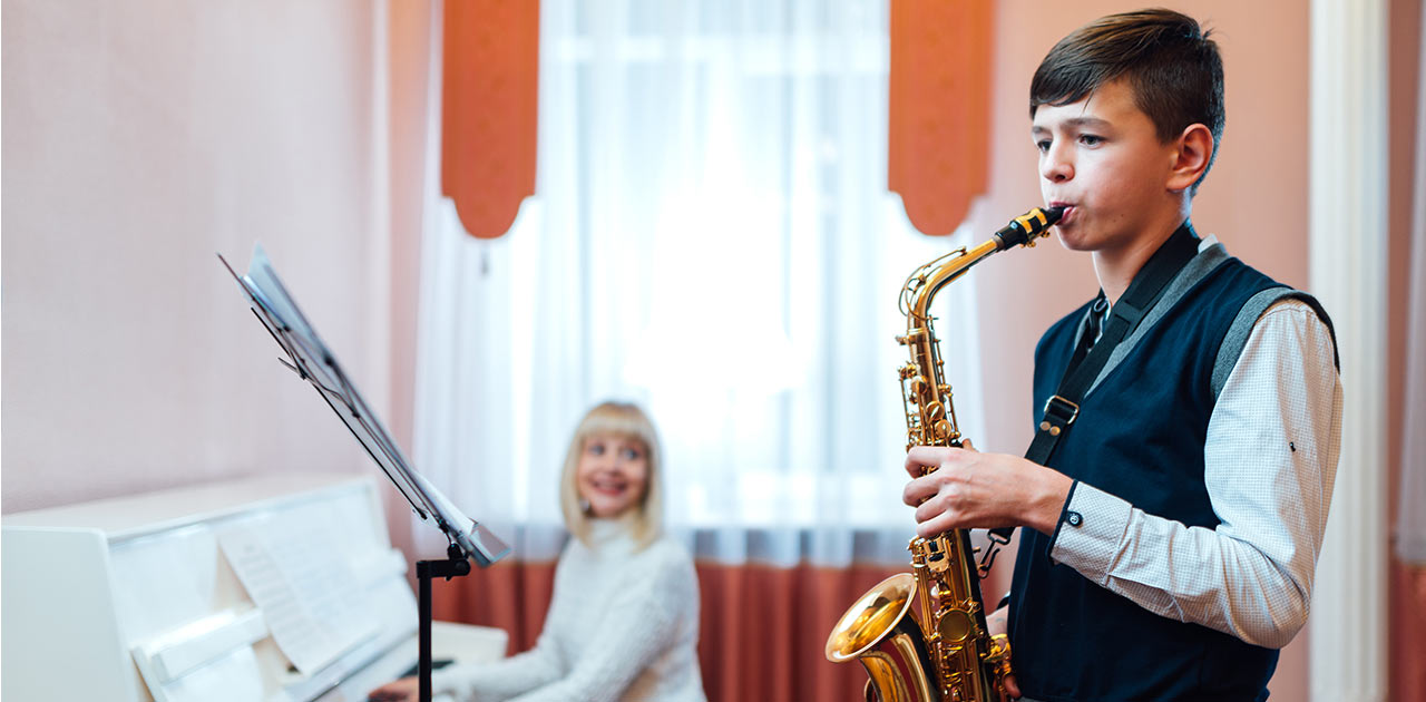 garoto estudando música em sua aula extracurricular